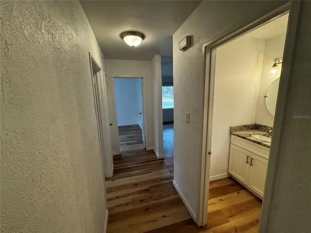 a view of a hallway with a door and wooden floor