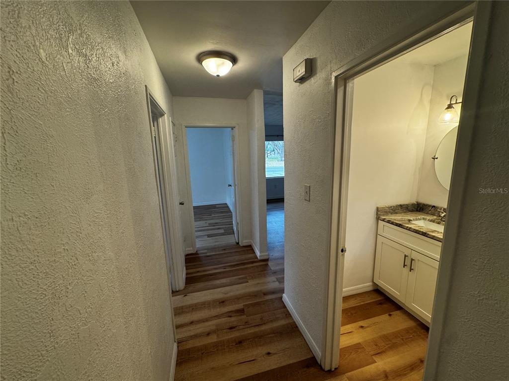 716 McCormack Street Leesburg, FL 34748 - Photo 11 of 13 a view of a hallway with a door and wooden floor