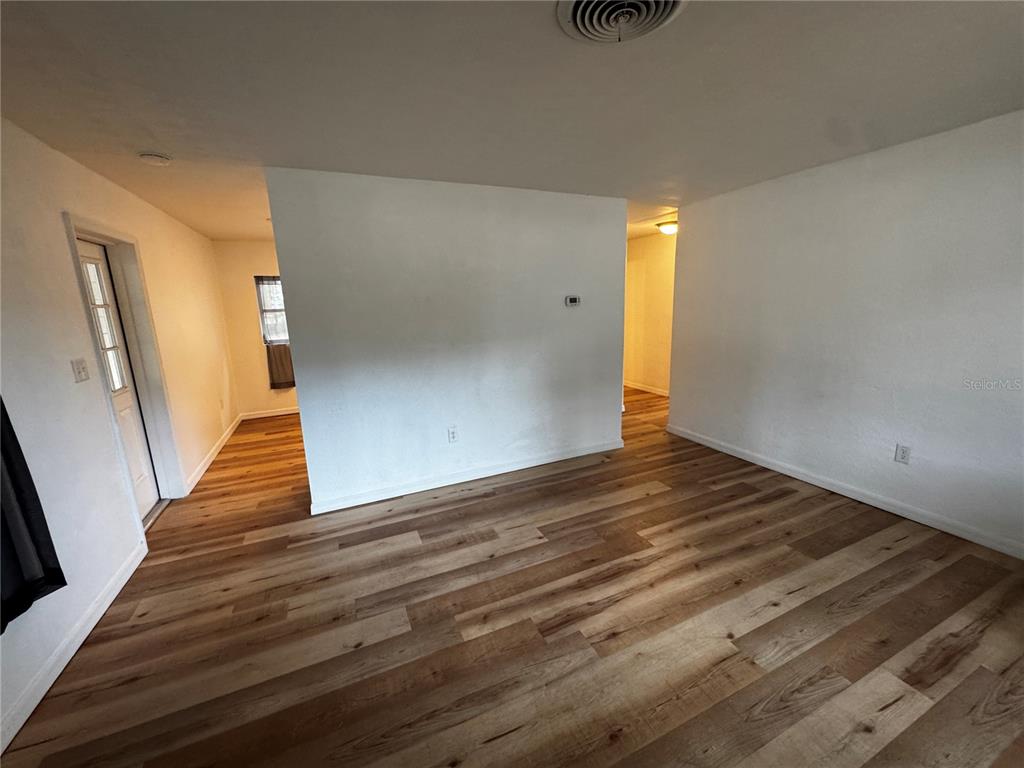 716 McCormack Street Leesburg, FL 34748 - Photo 3 of 13 a view of an empty room with wooden floor and stairs