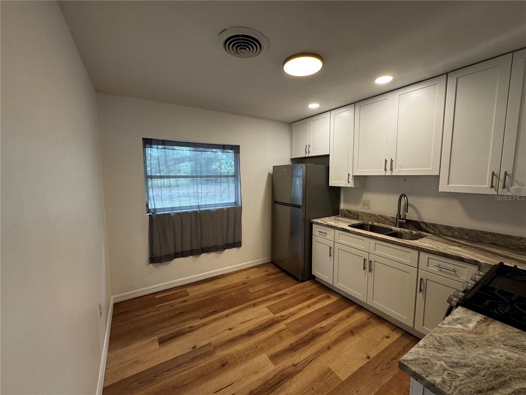 716 McCormack Street Leesburg, FL 34748 - Photo 4 of 13 a kitchen with stainless steel appliances granite countertop a refrigerator sink and stove
