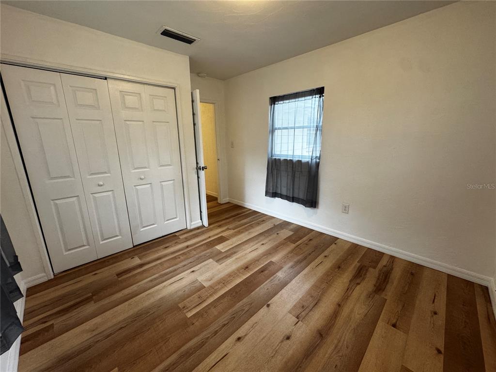 716 McCormack Street Leesburg, FL 34748 - Photo 9 of 13 a view of empty room with wooden floor and fan
