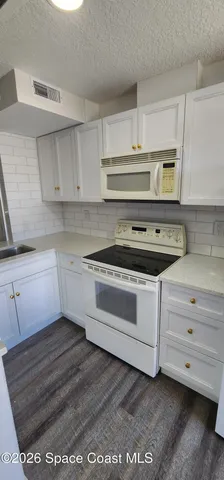 a kitchen with kitchen island a stove and a sink