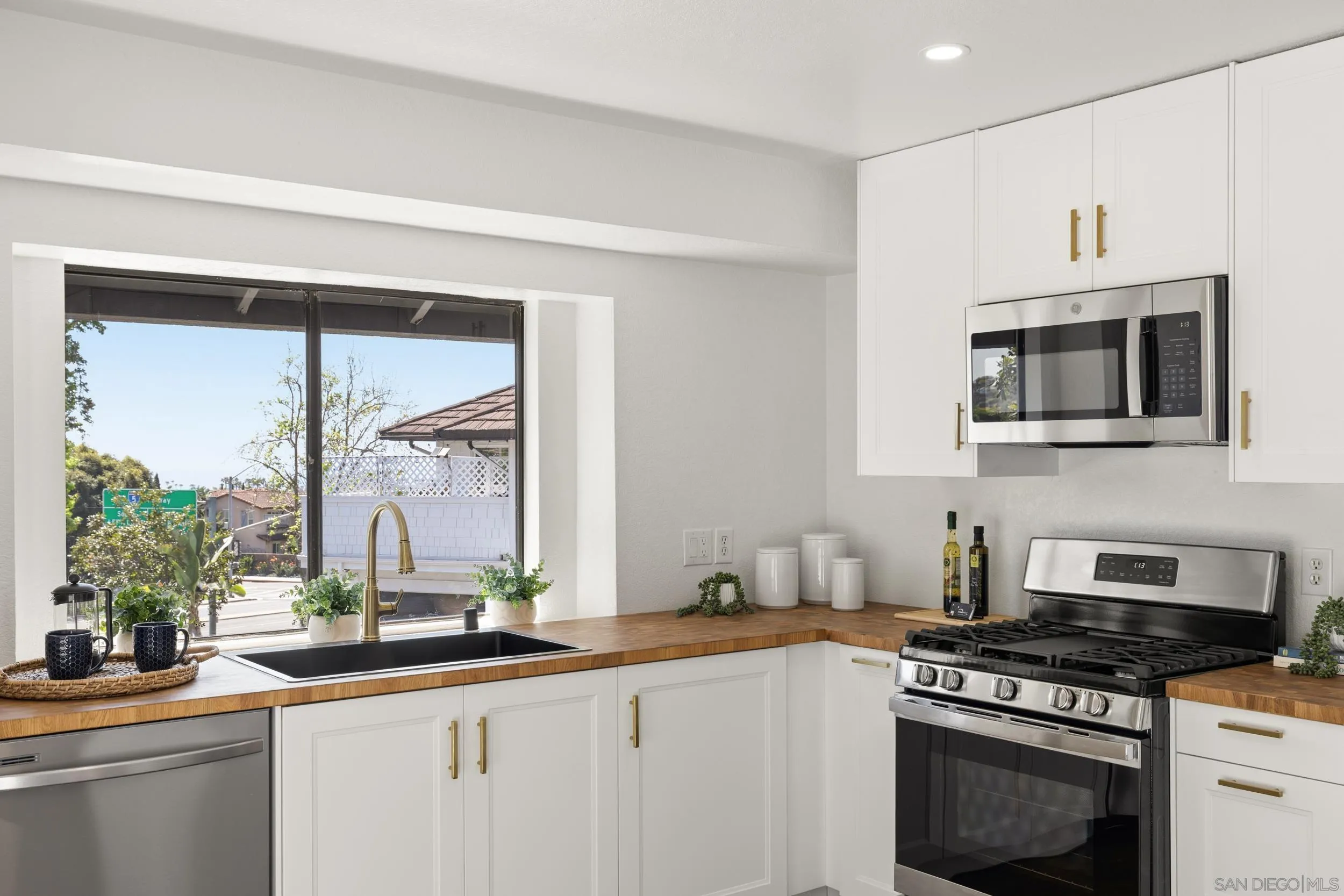 863 Violet Court Carlsbad, CA 92011 - Photo 12 of 37 a kitchen with stainless steel appliances a stove sink and microwave