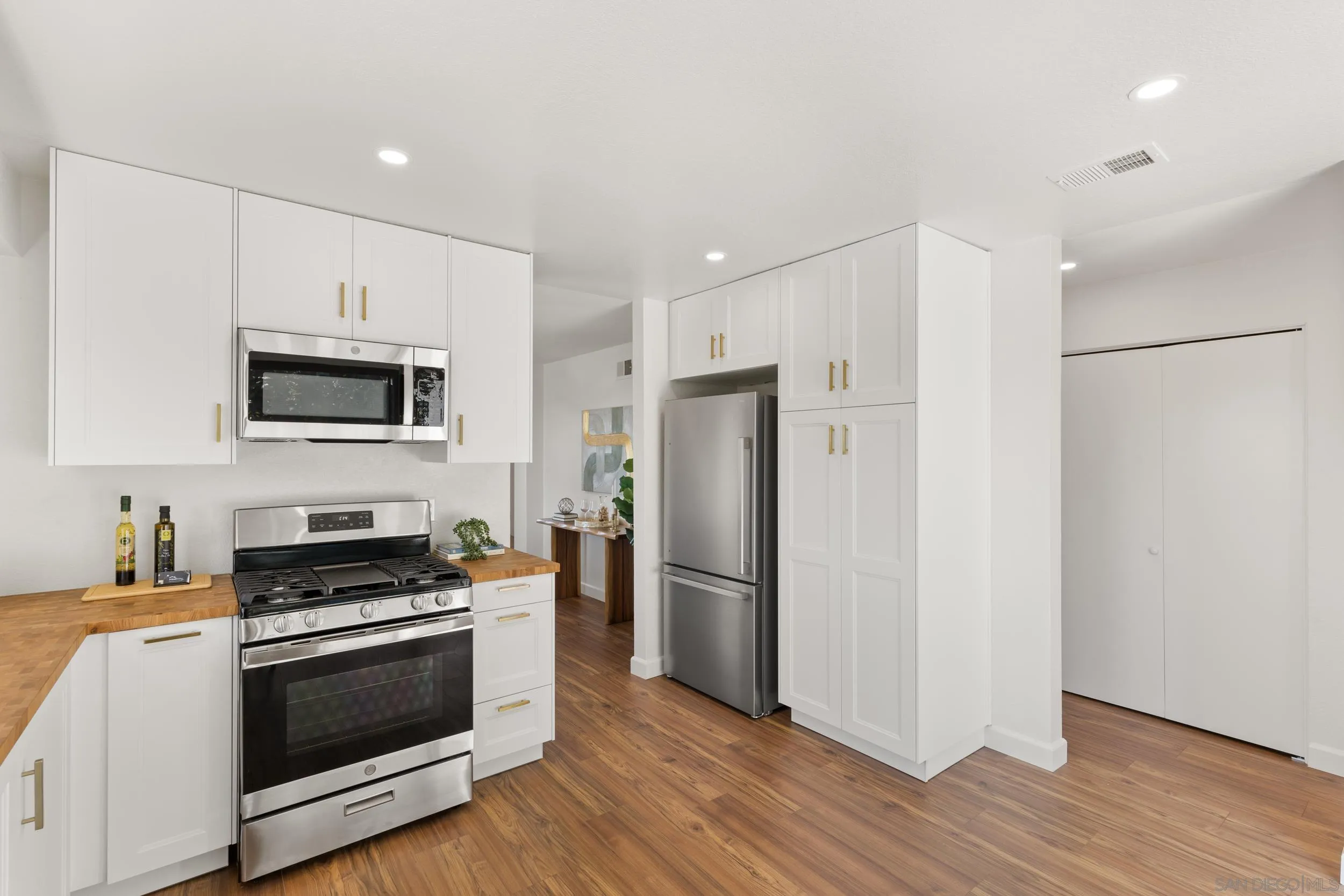 863 Violet Court Carlsbad, CA 92011 - Photo 13 of 37 a kitchen with a refrigerator stove and wooden floor