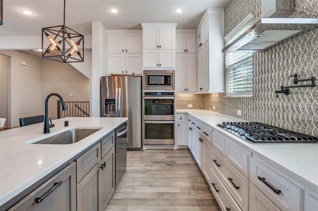 a kitchen with stainless steel appliances granite countertop a sink and a stove top oven