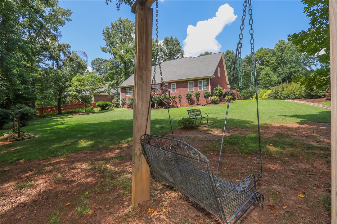 103 C-10-147D Anderson, SC 29621 - Photo 47 of 49 An inviting backyard oasis offers a lush lawn, mature trees, and ample space for relaxation or play.