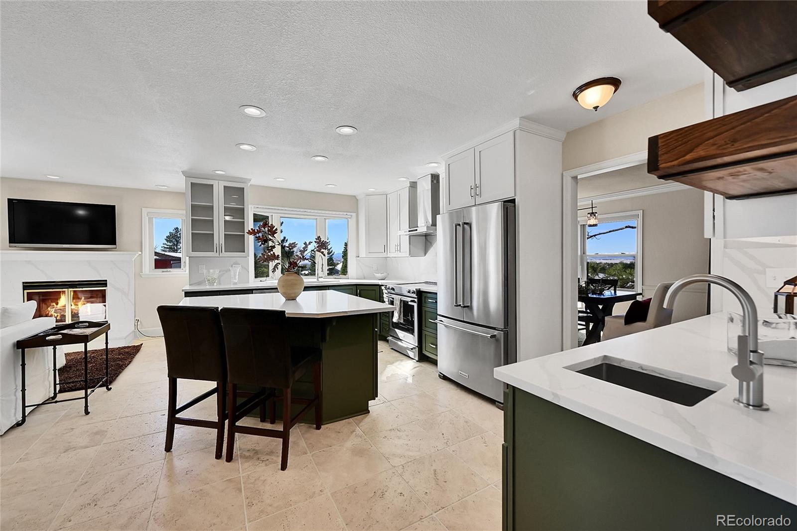 8717 Thunderbird Circle Parker, CO 80134 - Photo 15 of 50 a kitchen with a refrigerator a stove a sink dishwasher with a dining table and chair