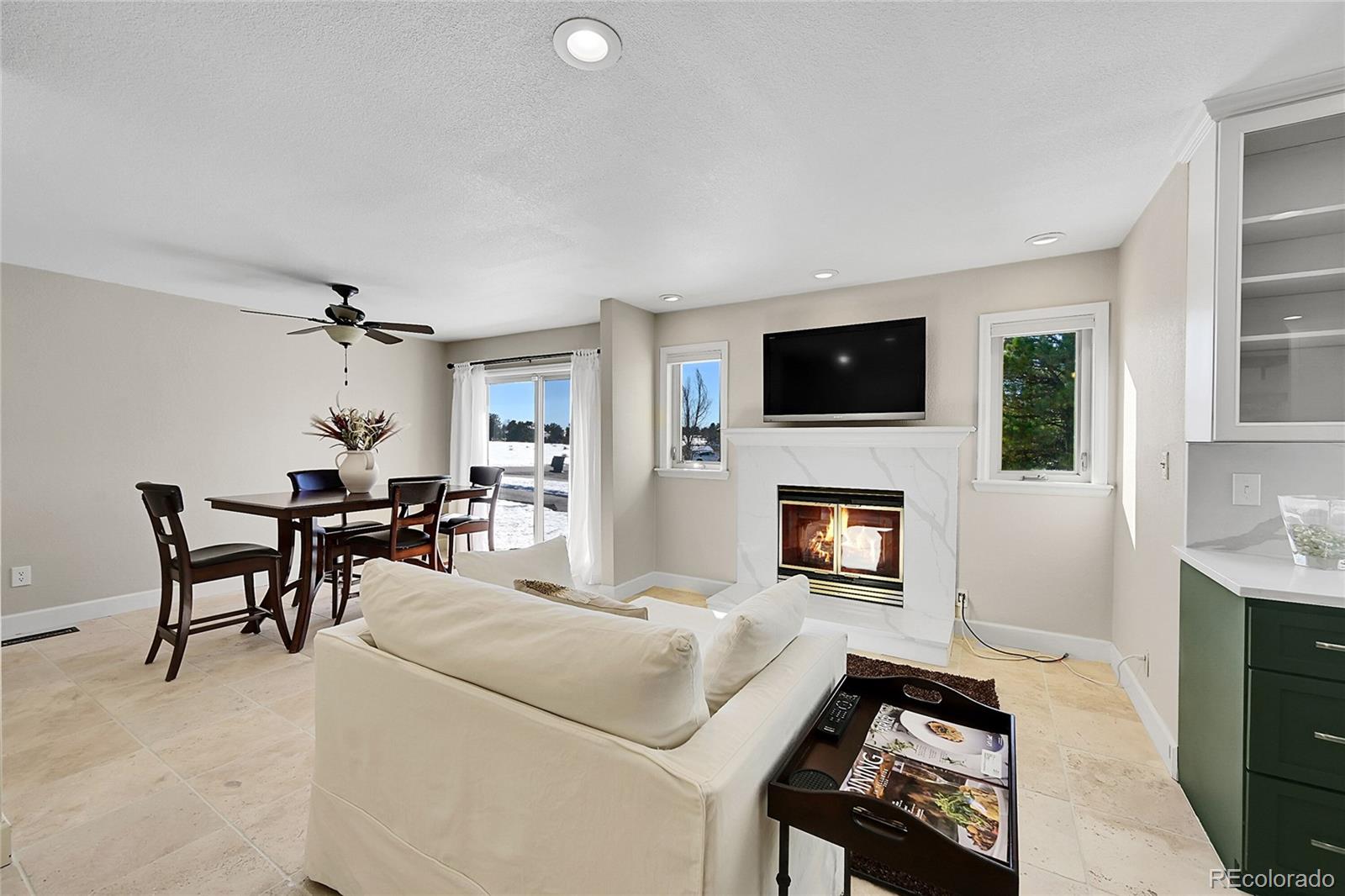 8717 Thunderbird Circle Parker, CO 80134 - Photo 20 of 50 a living room with furniture a fireplace and a flat screen tv