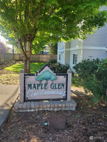 a view of a street sign under a large tree