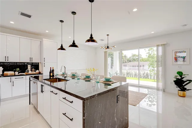 a kitchen with stainless steel appliances granite countertop a sink a stove and a refrigerator