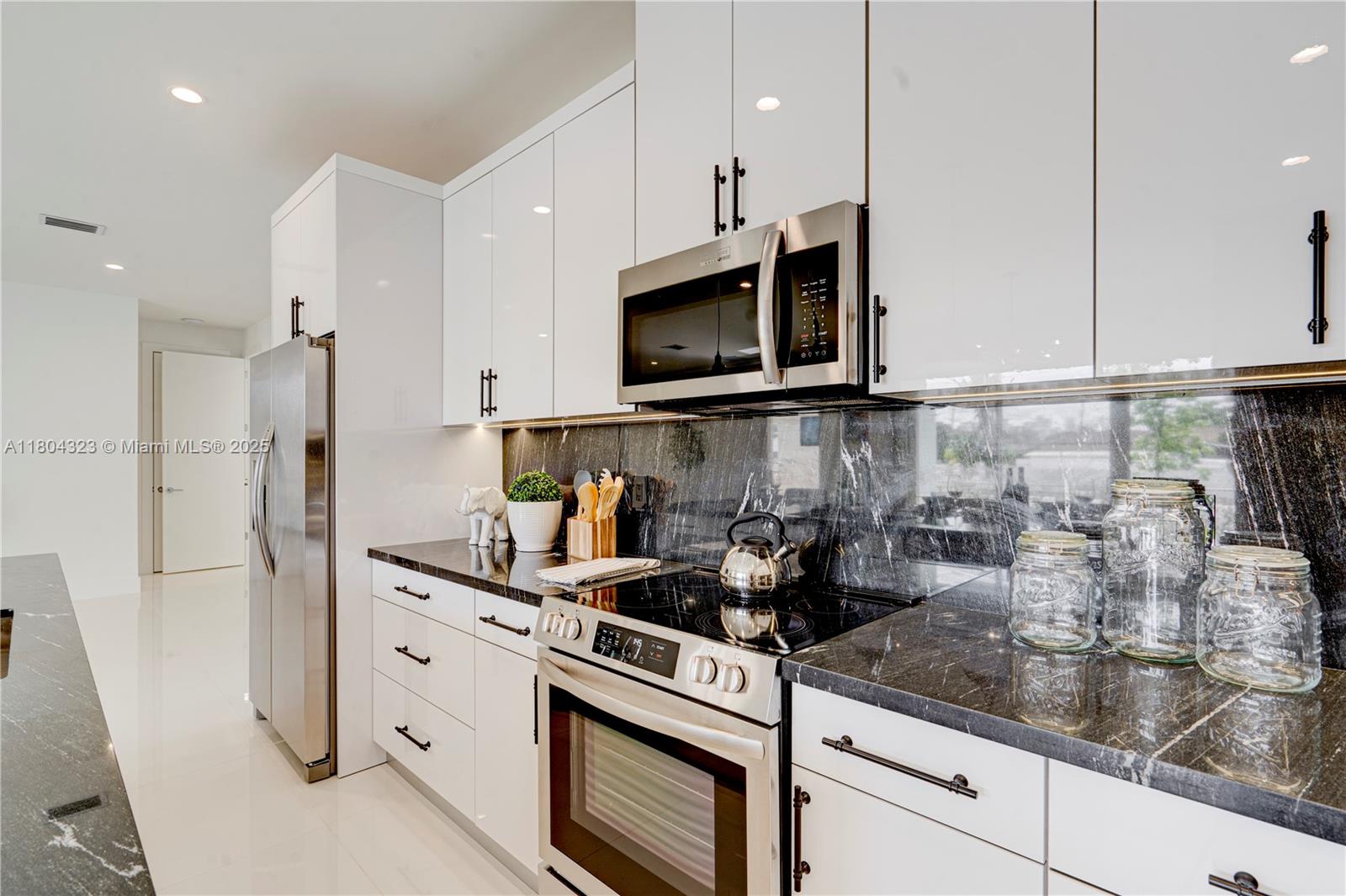 1805 Northwest 22nd Court Miami, FL 33125 - Photo 15 of 58 a kitchen with stainless steel appliances granite countertop a sink a stove and a refrigerator