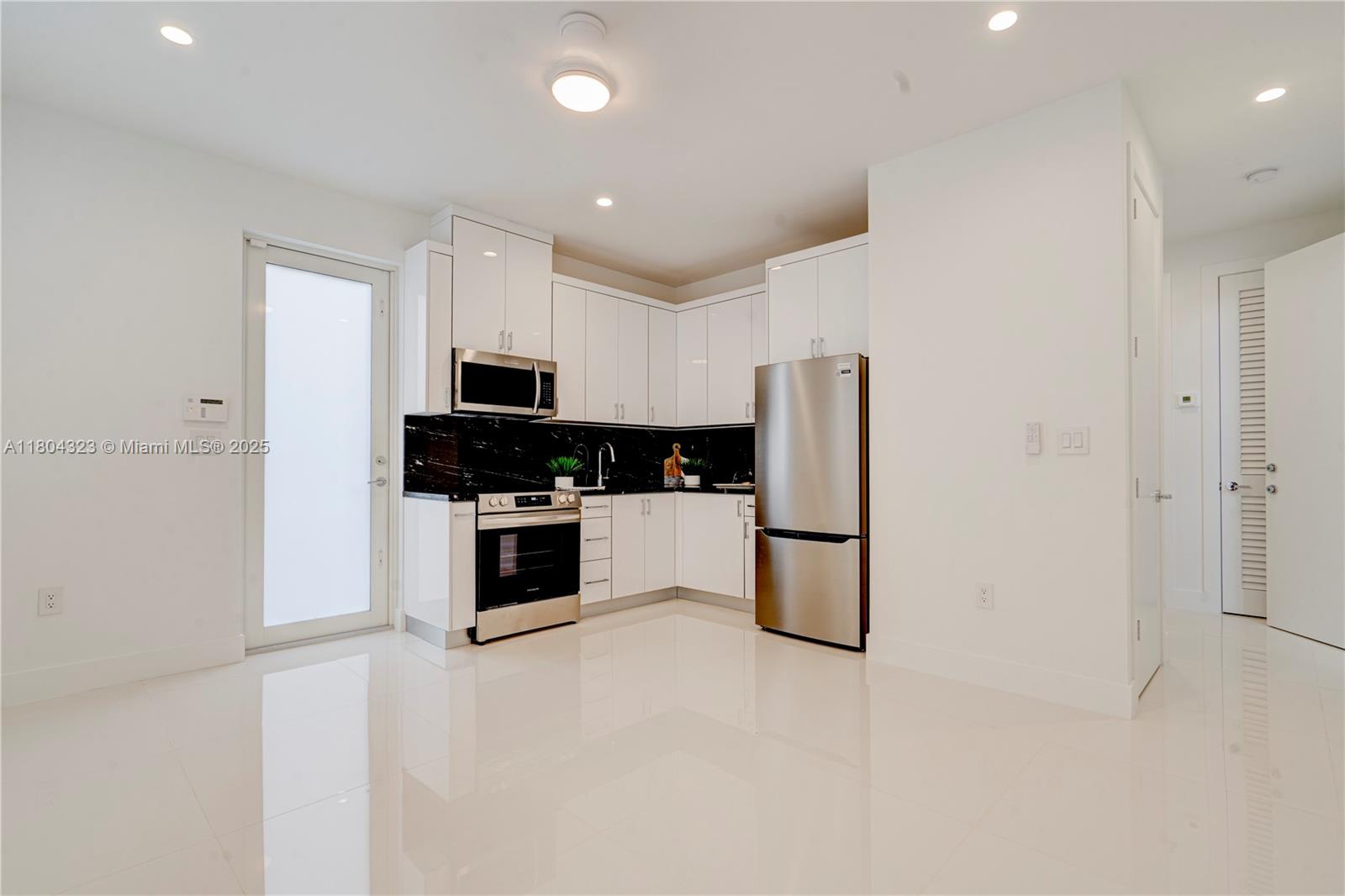 1805 Northwest 22nd Court Miami, FL 33125 - Photo 32 of 58 a kitchen with granite countertop a refrigerator and a stove top oven