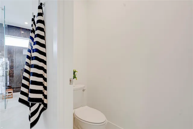 a backyard of a house with plants and large tree