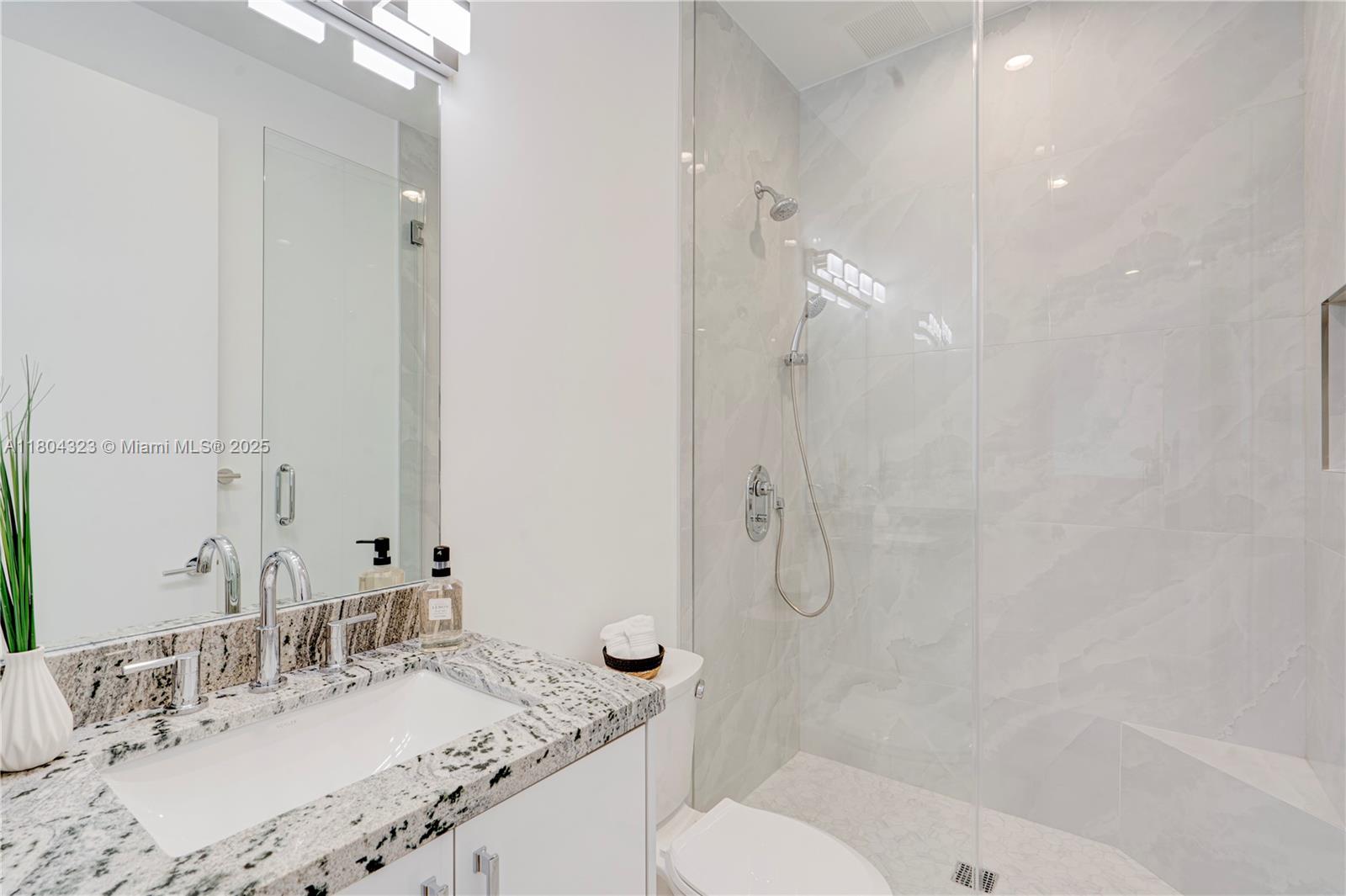 1805 Northwest 22nd Court Miami, FL 33125 - Photo 52 of 58 a bathroom with a granite countertop sink a toilet and shower