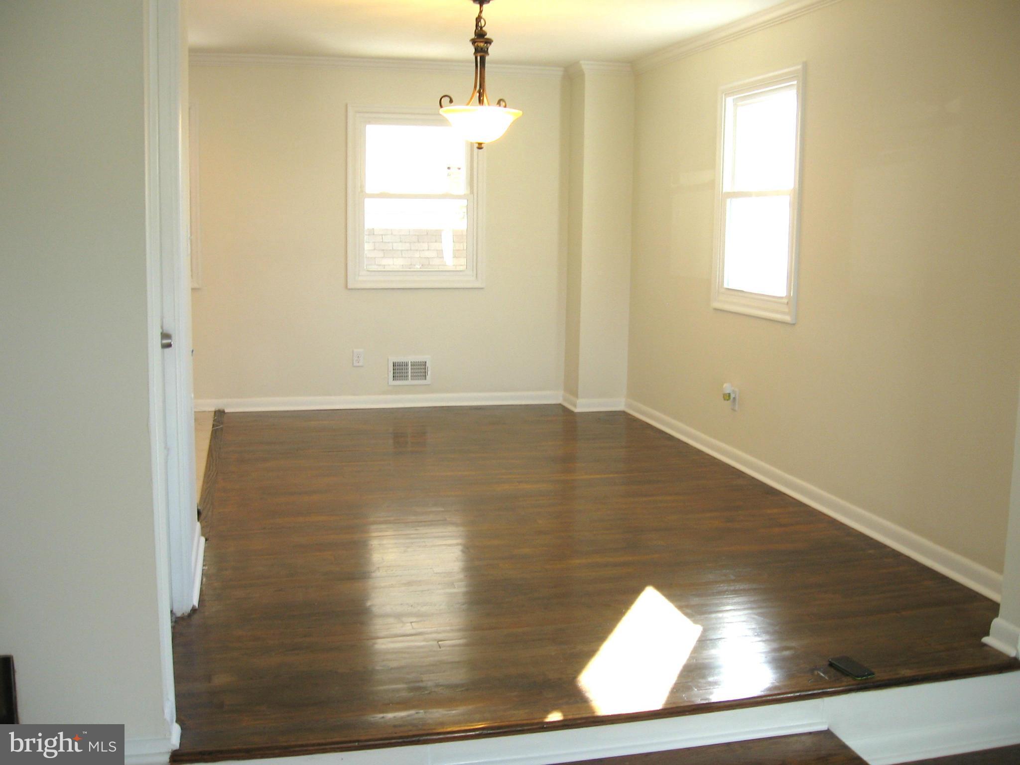 8245 Del Haven Road Baltimore, MD 21222 - Photo 1 of 29 an empty room with wooden floor and windows