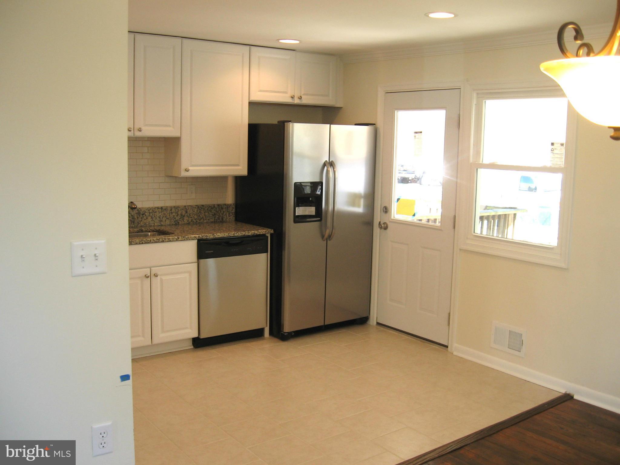 8245 Del Haven Road Baltimore, MD 21222 - Photo 2 of 29 a kitchen with a refrigerator a stove top oven and cabinets