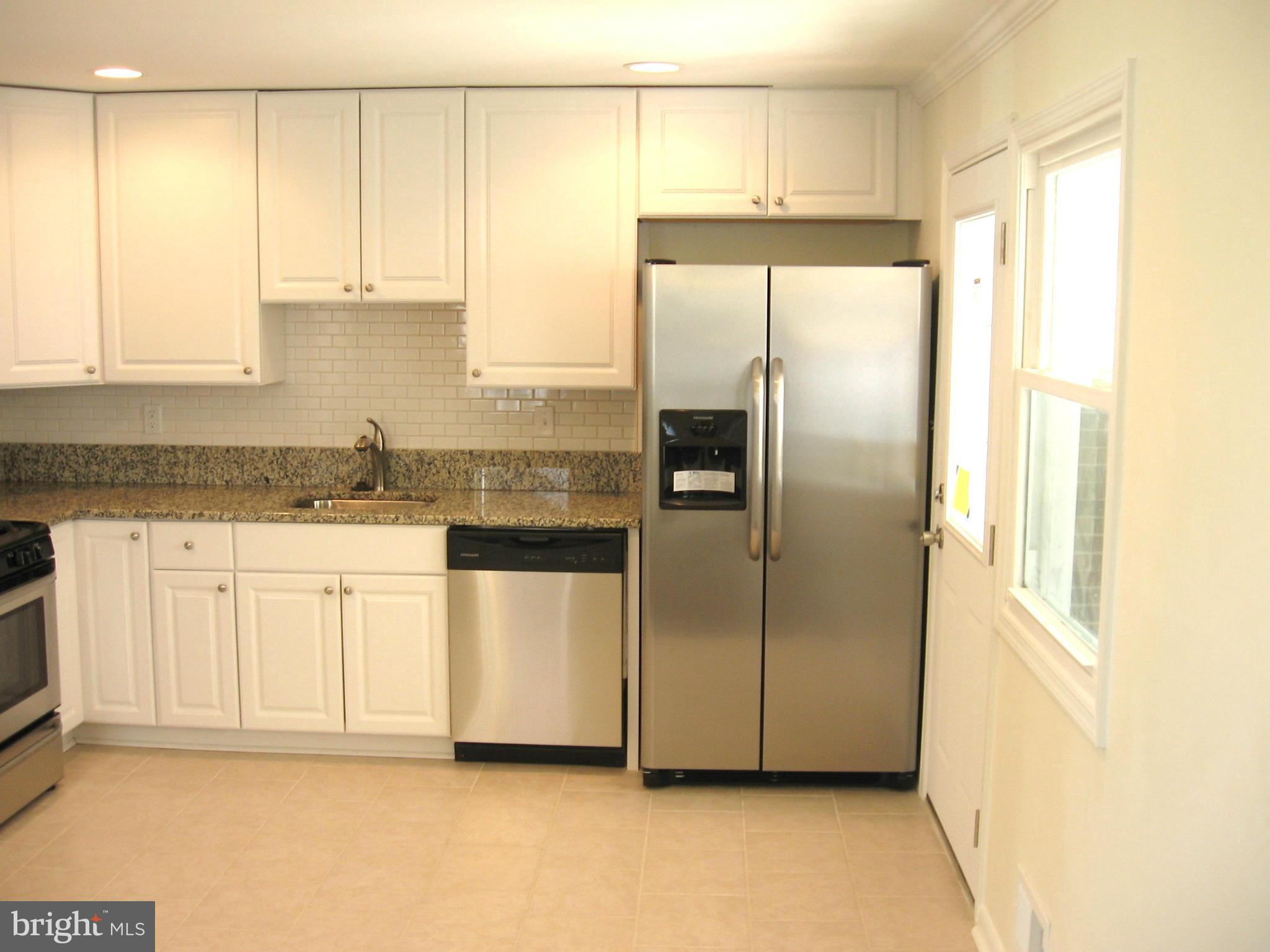 8245 Del Haven Road Baltimore, MD 21222 - Photo 3 of 29 a kitchen with granite countertop white cabinets and refrigerator