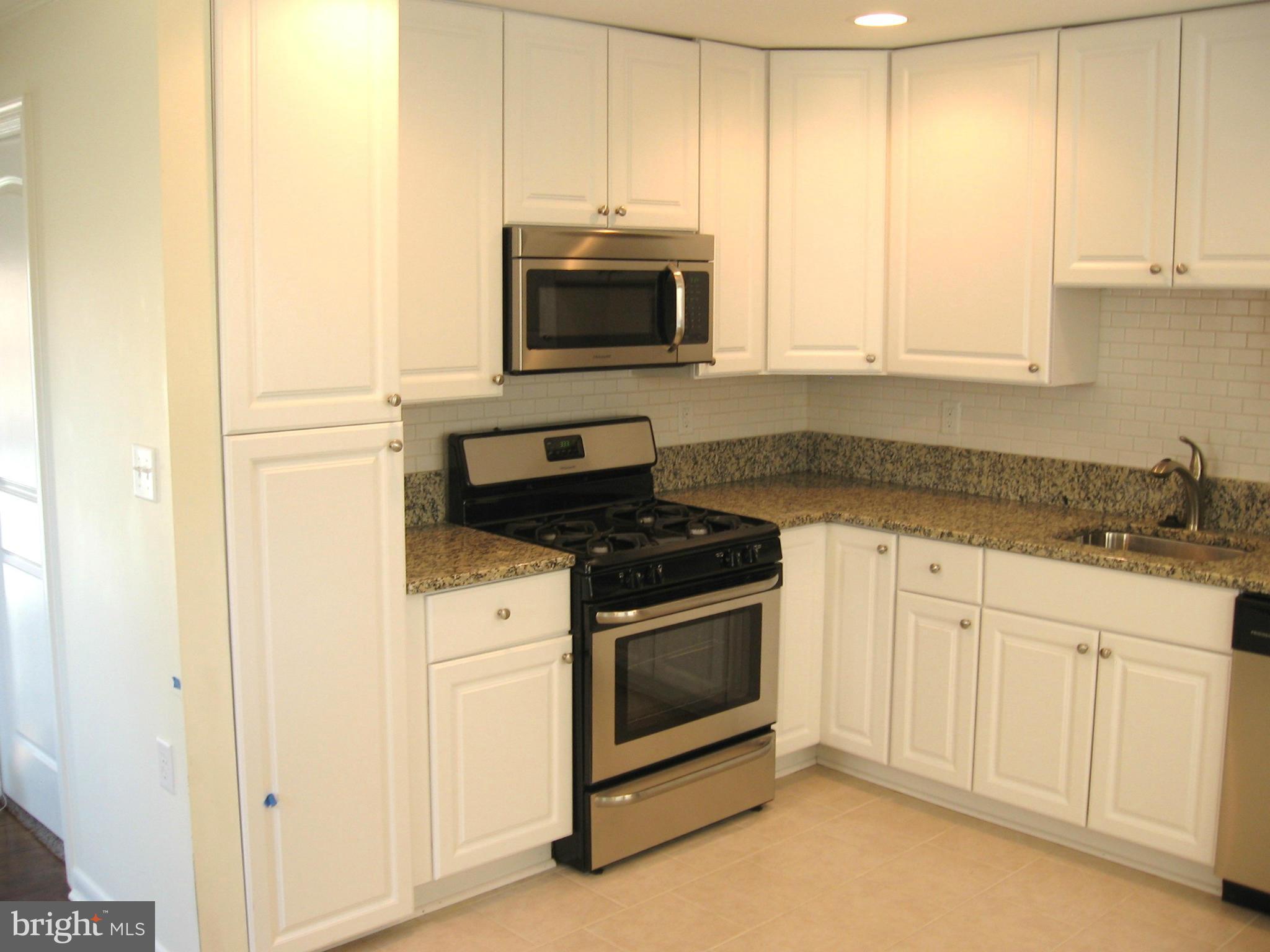 8245 Del Haven Road Baltimore, MD 21222 - Photo 5 of 29 a kitchen with granite countertop white cabinets and stainless steel appliances
