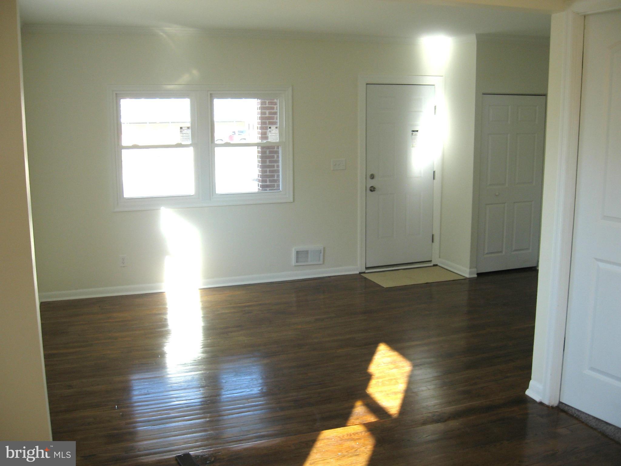8245 Del Haven Road Baltimore, MD 21222 - Photo 6 of 29 an empty room with wooden floor and windows