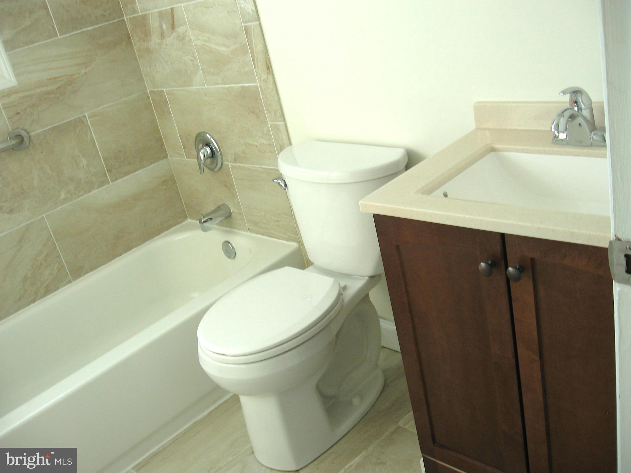 8245 Del Haven Road Baltimore, MD 21222 - Photo 9 of 29 a white toilet sitting next to a bathroom sink and a tub