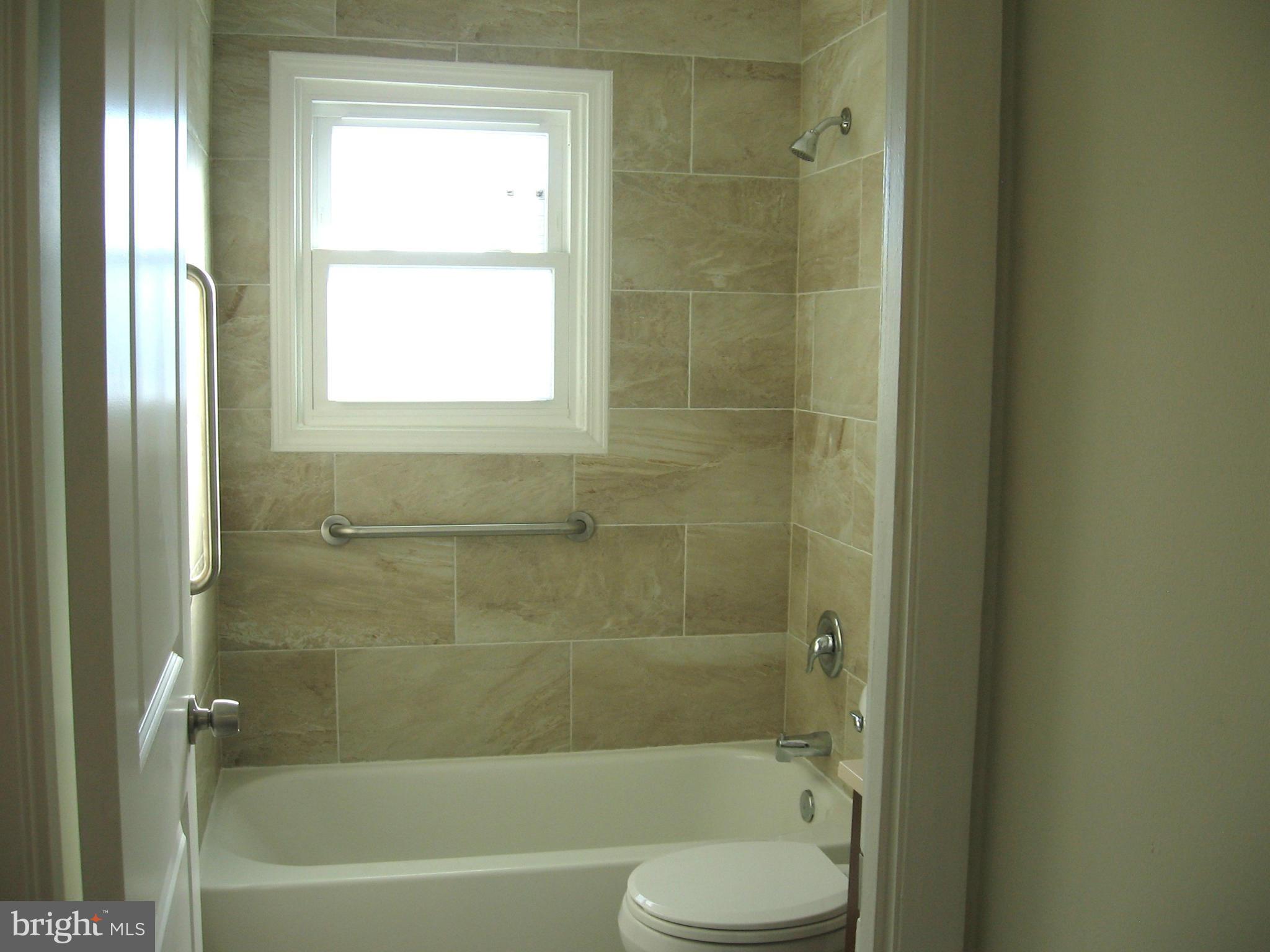 8245 Del Haven Road Baltimore, MD 21222 - Photo 10 of 29 a bathroom with a bathtub shower and toilet