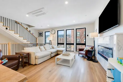 a living room with furniture large window and a flat screen tv