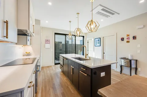 a kitchen with granite countertop a sink a counter top space and stainless steel appliances