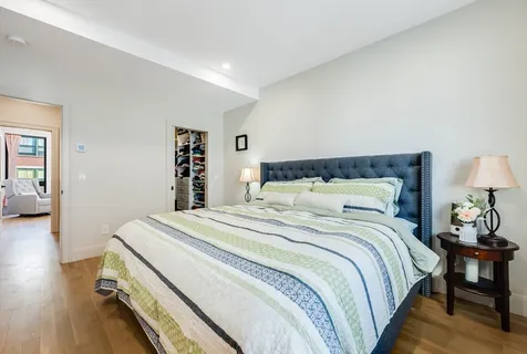 a bedroom with bed and wooden floor