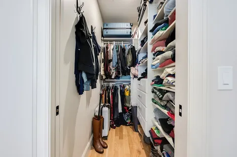 a view of walk in closet with clothes and shoes