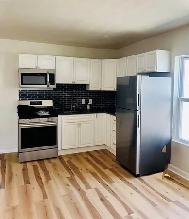 a kitchen with granite countertop a refrigerator and a stove top oven