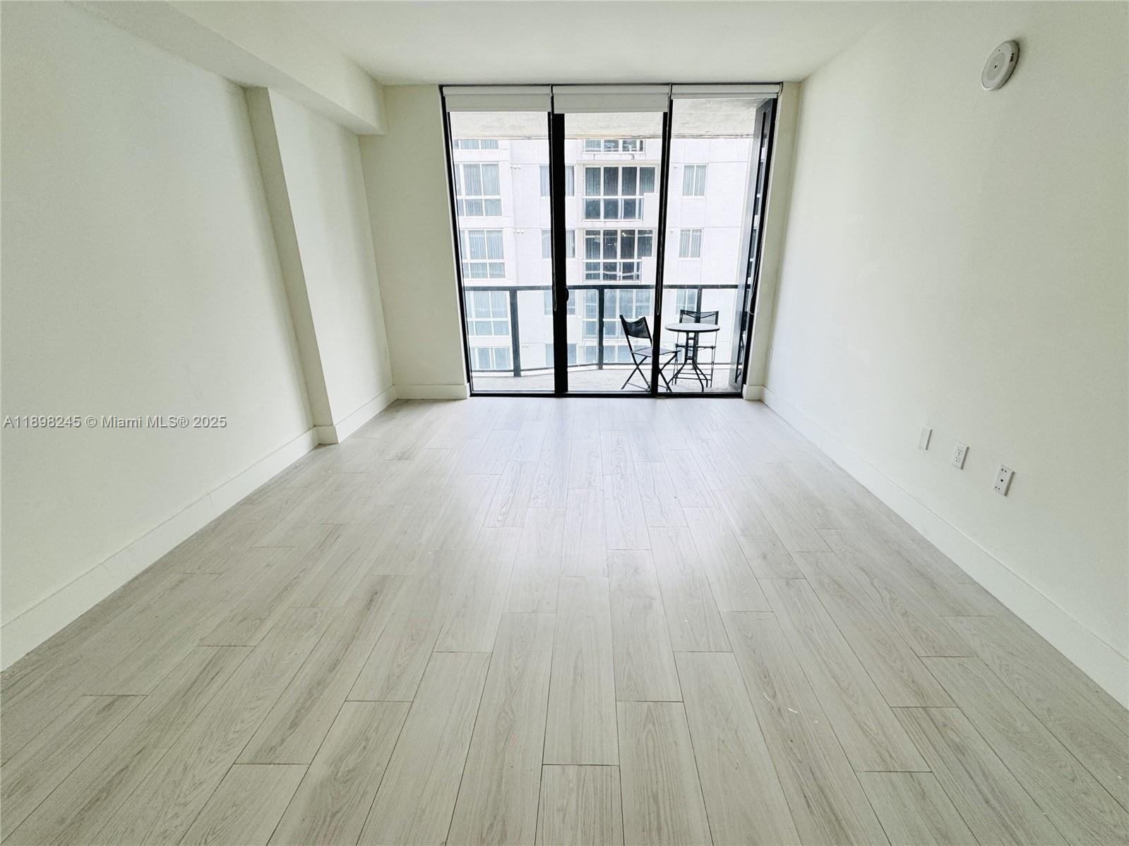 201 Southwest 17th Road, Unit 603 Miami, FL 33129 - Photo 5 of 23 wooden floor in an empty room with a window