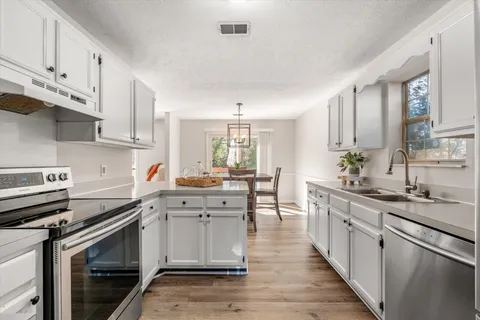 a kitchen with stainless steel appliances a sink stove and cabinets