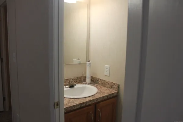 a bathroom with a granite countertop sink and a mirror