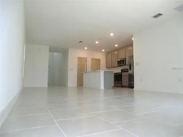 a view of a kitchen with a sink and an empty room