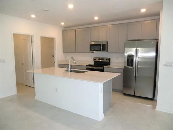 a kitchen with kitchen island a counter top space stainless steel appliances and cabinets