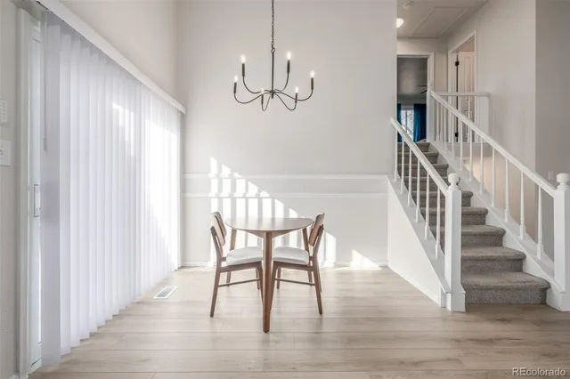 a view of a dining room with wooden floor windows and entryway