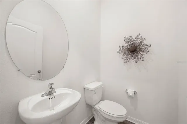 a bathroom with a toilet sink and mirror