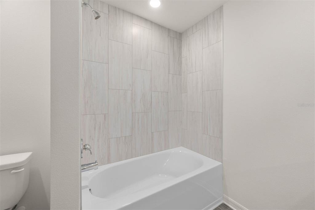 685 Poppy Lane Dundee, FL 33838 - Photo 28 of 31 a bathroom with a white bath tub and a shower curtain