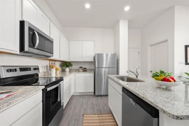 a kitchen with stainless steel appliances granite countertop a sink stove and refrigerator