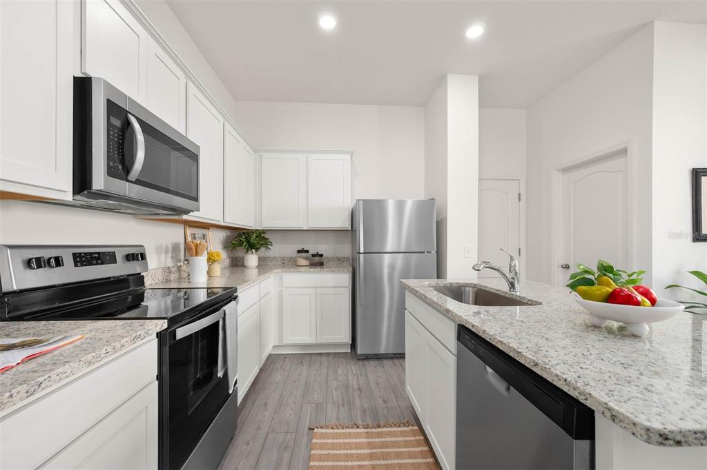 685 Poppy Lane Dundee, FL 33838 - Photo 5 of 31 a kitchen with stainless steel appliances granite countertop a sink stove and refrigerator