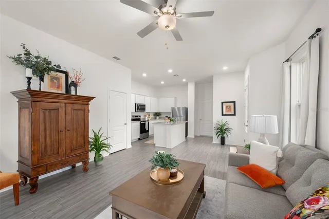 a living room with furniture kitchen view and a potted plant