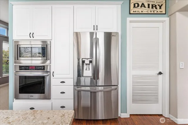 a metallic refrigerator freezer sitting in a kitchen