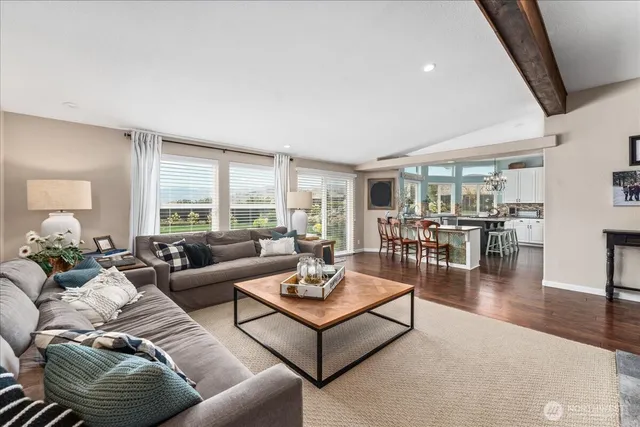 a living room with furniture wooden floor and a large window