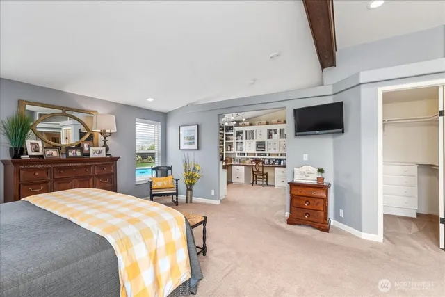 a spacious bedroom with a bed and a flat screen tv