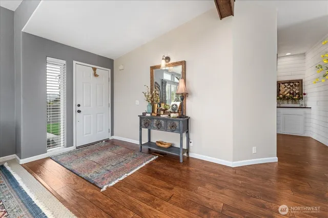 a view of a hallway with wooden floor and furniture