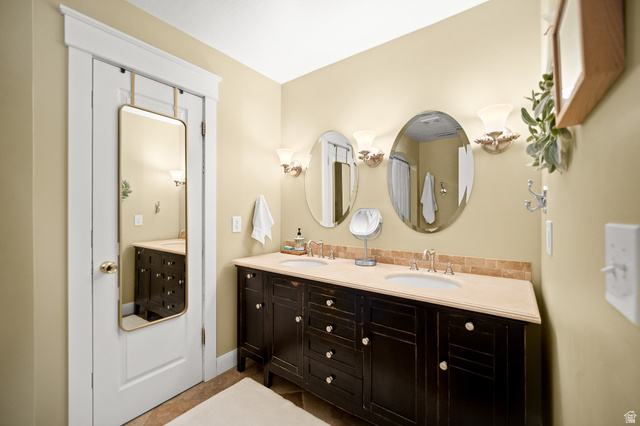 236 West 300 South Hurricane, UT 84737 - Photo 40 of 76 Bathroom featuring a double vanity with dark wood cabinetry, light-toned countertop, and dual oval mirrors