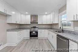 a kitchen with stainless steel appliances granite countertop a sink stove and cabinets