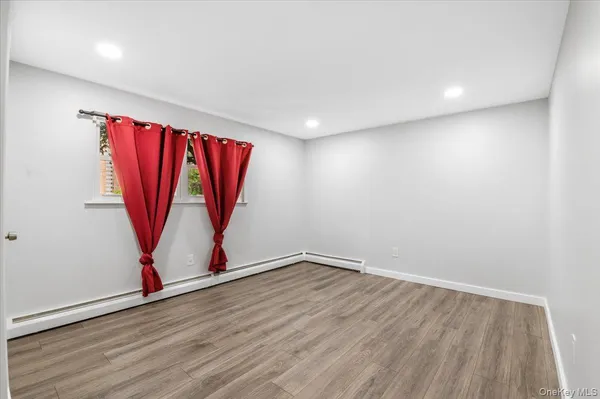 a view of a room with wooden floor and a window