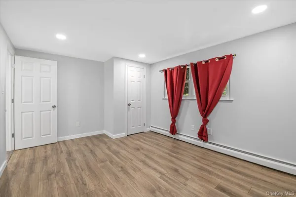 a view of a room with wooden floor and white walls