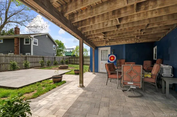 a view of a patio with table and chairs with wooden floor and fence
